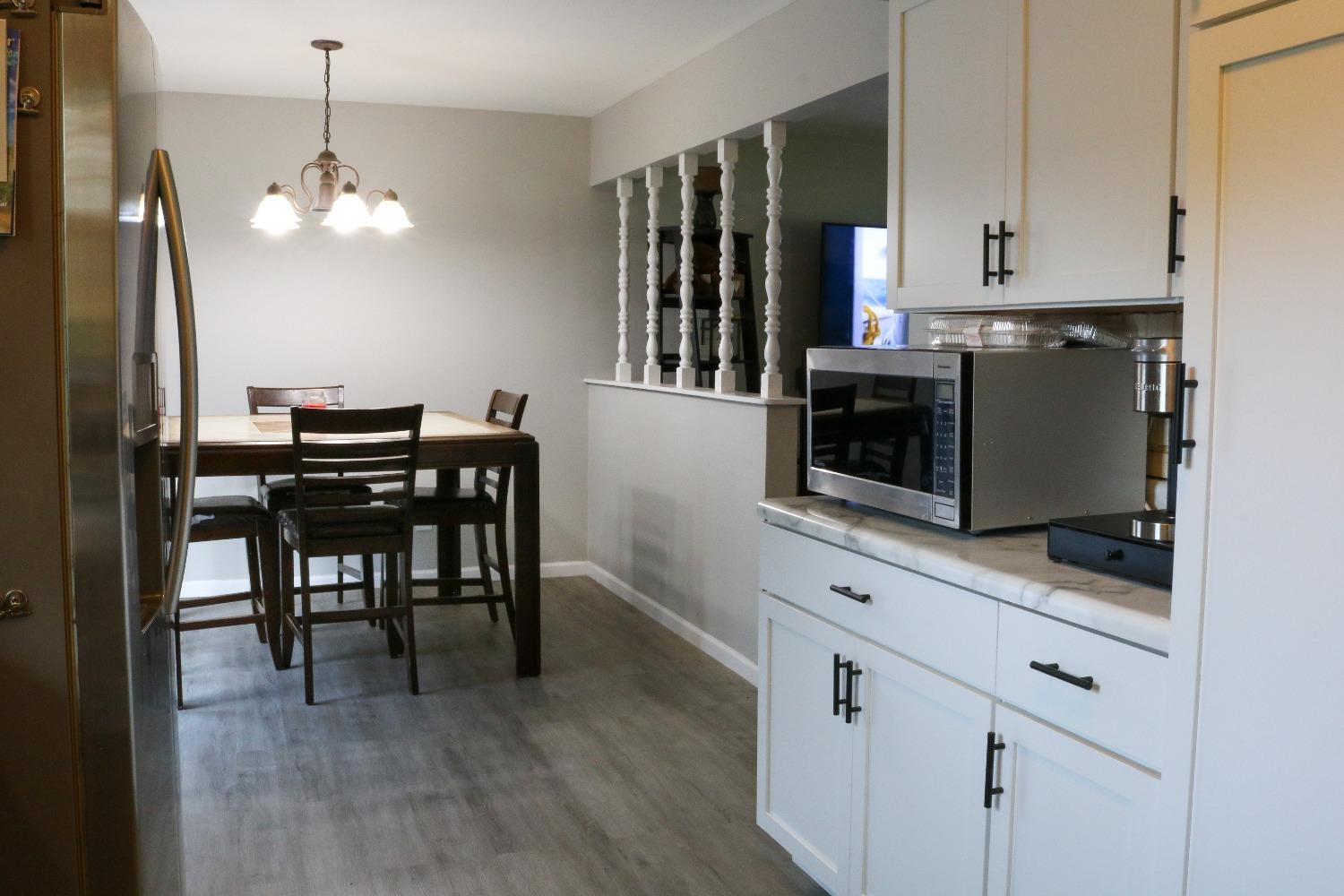 8469 Morse Court Crown Point, IN 46307 - Photo 9 of 33 a kitchen with stainless steel appliances granite countertop a stove top oven a refrigerator a sink and dishwasher with wooden floor