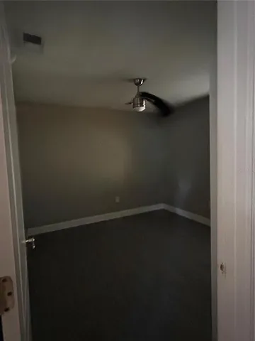 a view of an empty room with closet and window