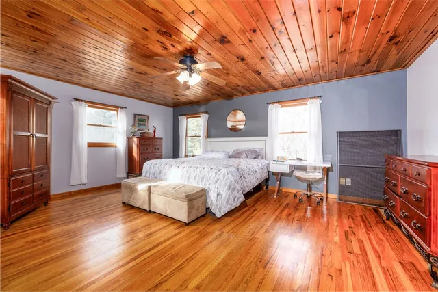 a spacious bedroom with a bed wooden floor and window