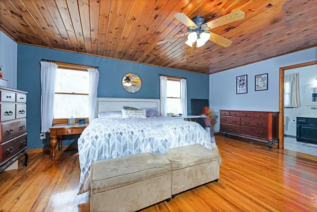 a bedroom with a bed wooden floor and window