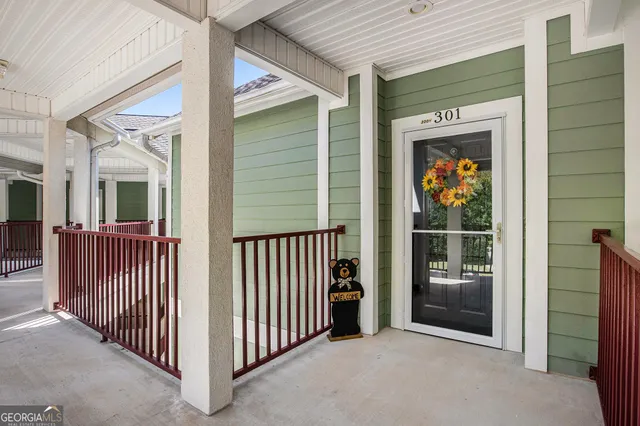 a view of a porch with a door and wooden floor