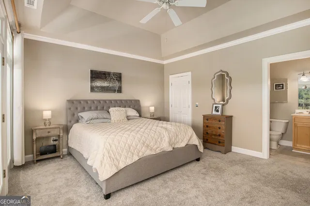 a bedroom with a bed a mirror and lamp