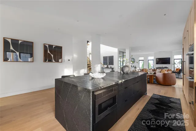 a large kitchen with stainless steel appliances a large counter top a stove and a sink