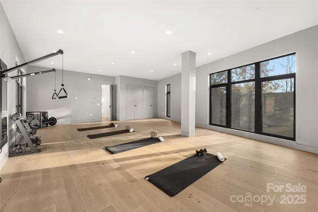 a living room with furniture gym equipment and a large window