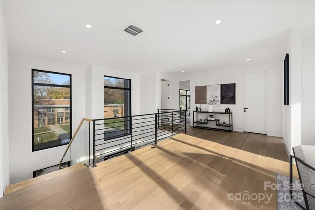 a spacious bedroom with a bed and a flat tv screen