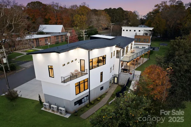 an aerial view of residential house with outdoor space and trees all around
