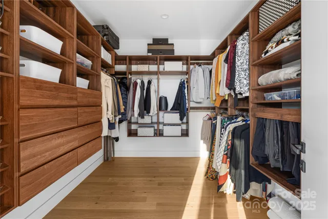 a view of walk in closet with clothes and shoes