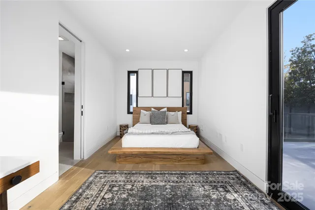 a large bedroom with a bed and wooden floor