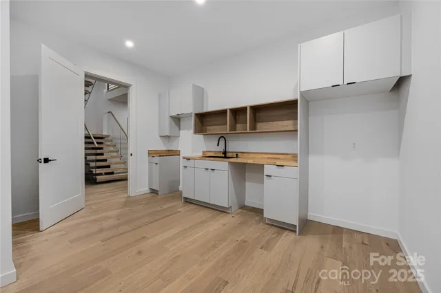 a view of empty room with wooden floor and sink