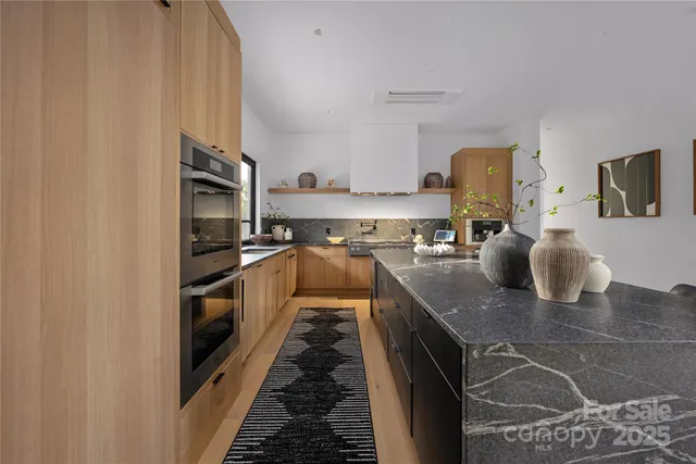 a kitchen with stainless steel appliances granite countertop a sink and a stove