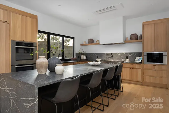 a kitchen with a dining table chairs and refrigerator