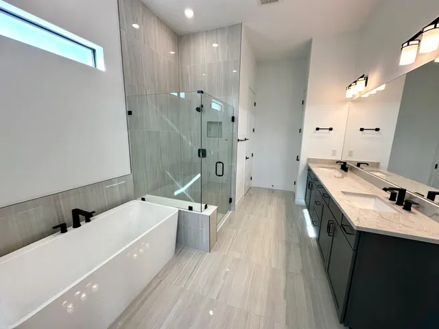 a view of a bathroom with a tub sink a mirror and a shower