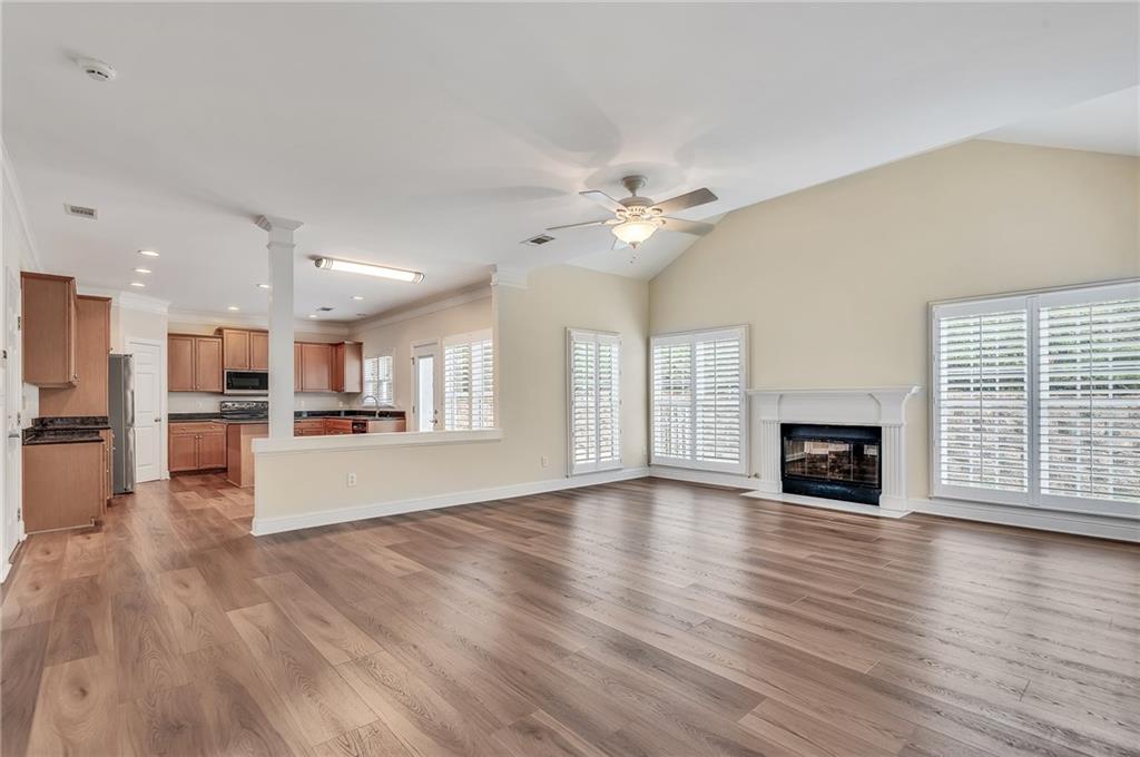 4115 Montvale Crossing Cumming, GA 30041 - Photo 13 of 38 a view of an empty room with wooden floor and a kitchen