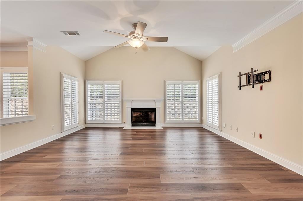 4115 Montvale Crossing Cumming, GA 30041 - Photo 14 of 38 an empty room with wooden floor fireplace and windows