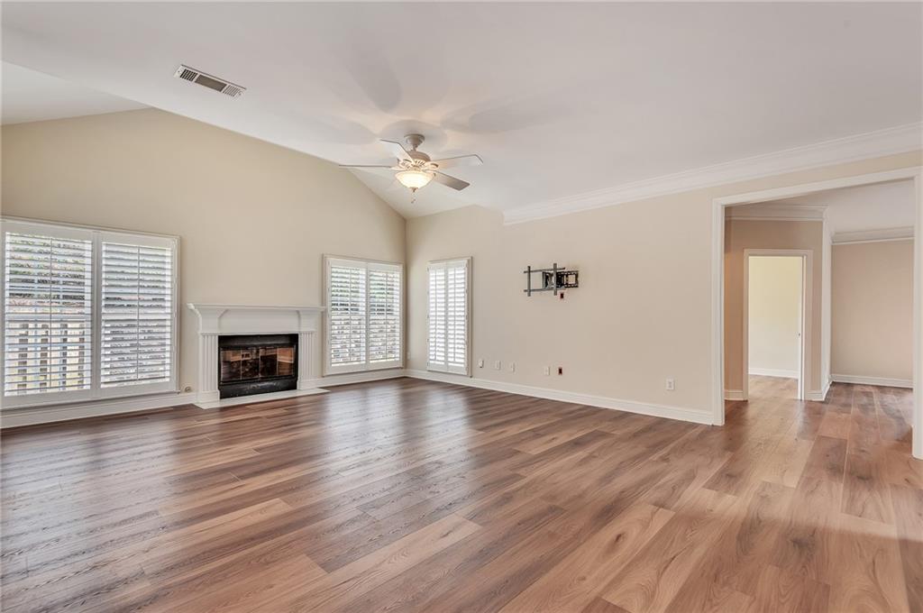 4115 Montvale Crossing Cumming, GA 30041 - Photo 16 of 38 an empty room with wooden floor fireplace and windows