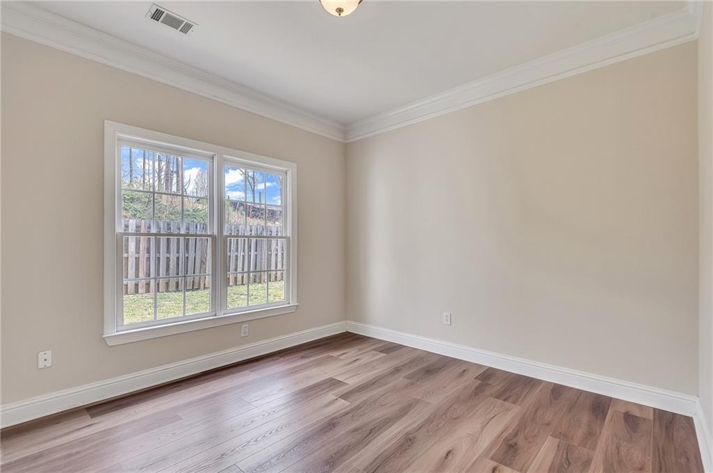 4115 Montvale Crossing Cumming, GA 30041 - Photo 22 of 38 a view of an empty room with wooden floor and a window