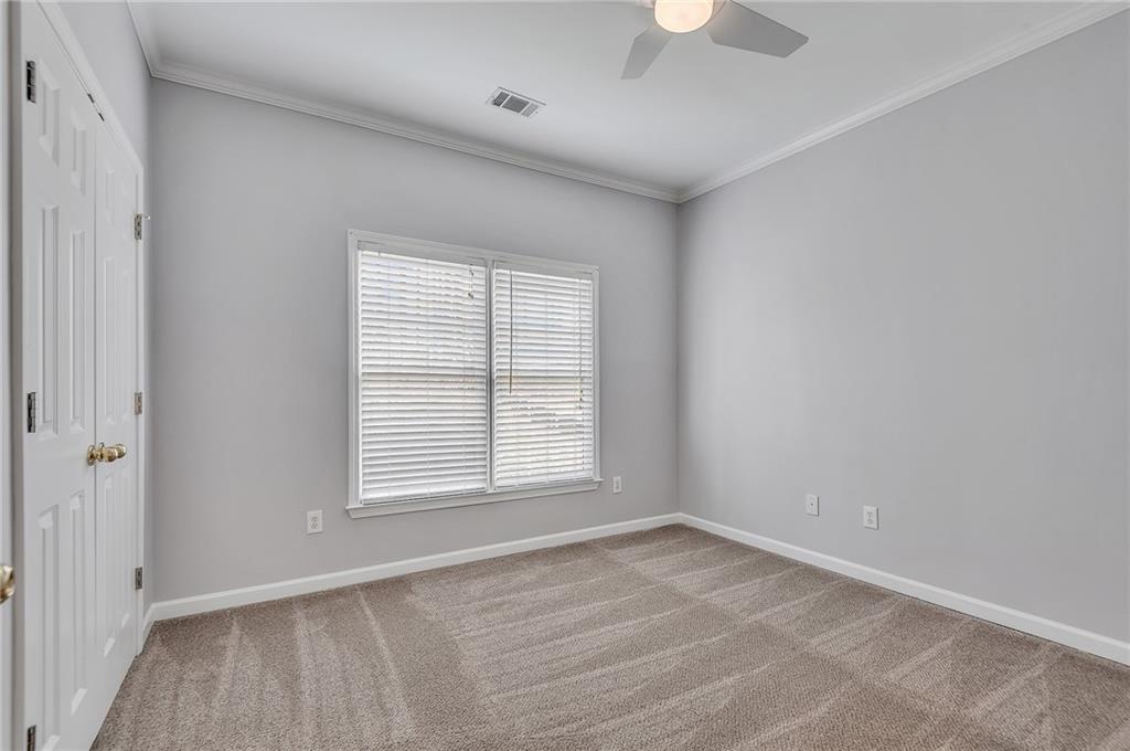 4115 Montvale Crossing Cumming, GA 30041 - Photo 30 of 38 an empty room with a window and a chandelier fan