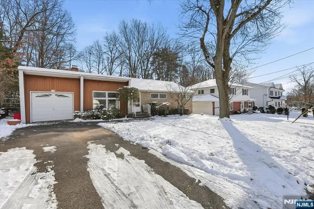 a front view of a house with a yard covered in snow