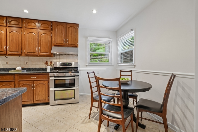 106 Division Avenue Summit, NJ 07901 - Photo 12 of 38 a kitchen with stainless steel appliances granite countertop a stove a sink a microwave and a refrigerator