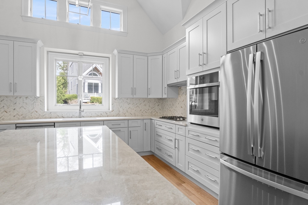 10 Deer Path Lane, Unit 10 Reading, MA 01867 - Photo 6 of 23 a kitchen with granite countertop a refrigerator a sink a stove and cabinets