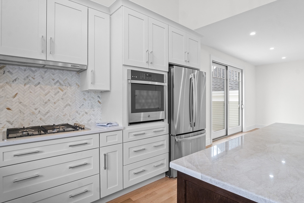 10 Deer Path Lane, Unit 10 Reading, MA 01867 - Photo 7 of 23 a kitchen with granite countertop cabinets and steel stainless steel appliances