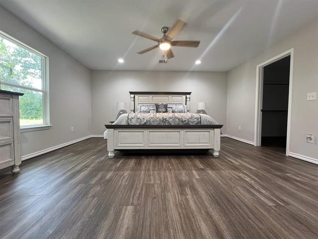 10516 Peck Road Lumberton, TX 77657 - Photo 13 of 27 a spacious bedroom with a large bed a chandelier and windows