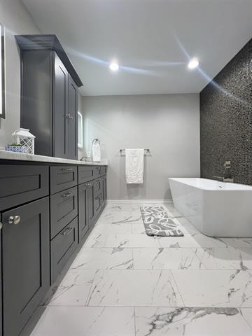 10516 Peck Road Lumberton, TX 77657 - Photo 21 of 27 a spacious bathroom with a double vanity sink and a bathtub