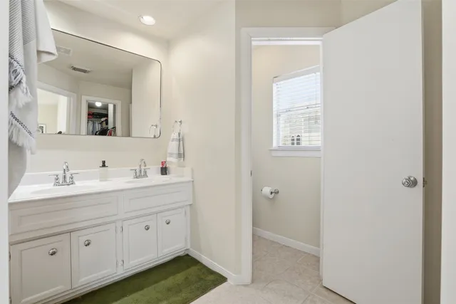 a bathroom with a double vanity sink and a mirror