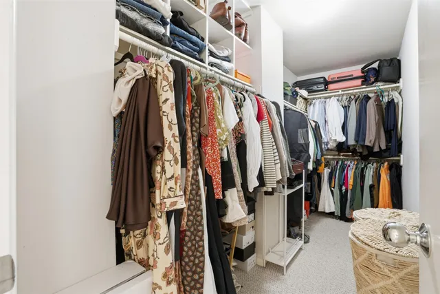 a view of walk in closet with clothes