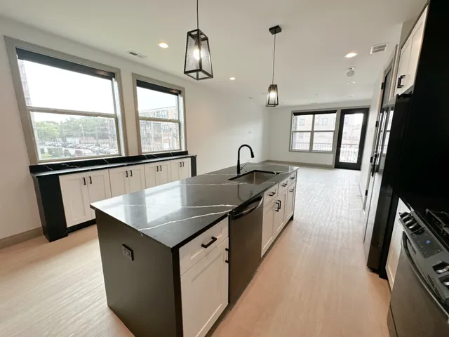 a kitchen with stainless steel appliances kitchen island granite countertop a refrigerator and a sink