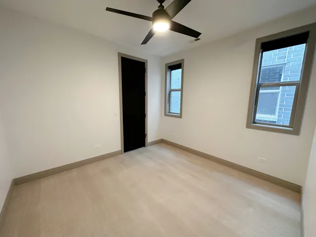 an empty room with windows and fan