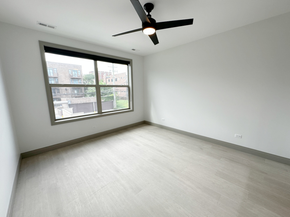 4054 South Indiana Avenue, Unit 2R Chicago, IL 60653 - Photo 10 of 17 an empty room with windows and fan