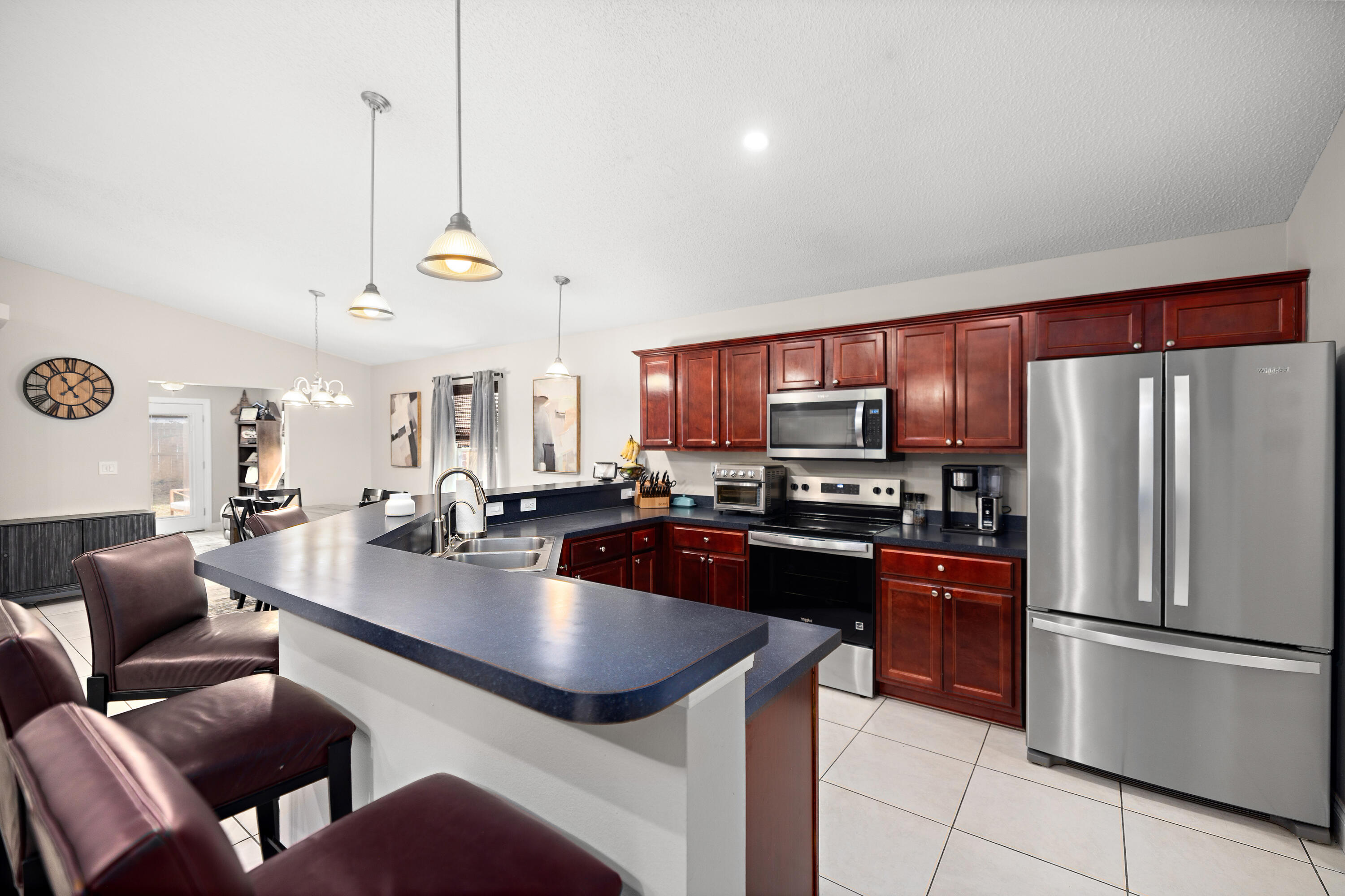 202 Limestone Circle Crestview, FL 32539 - Photo 2 of 49 a kitchen with stainless steel appliances granite countertop a refrigerator a stove a sink a dining table and chairs with wooden floor