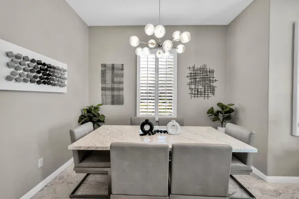 a dining room with chandelier and wooden floor