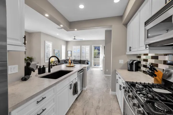 a kitchen with sink a stove and cabinets