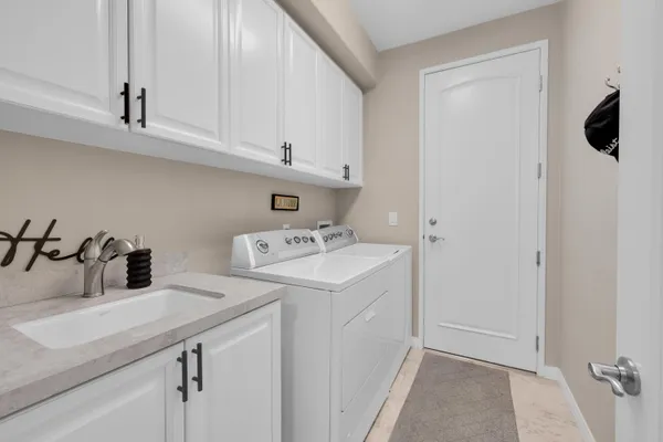 a utility room with sink dryer and washer