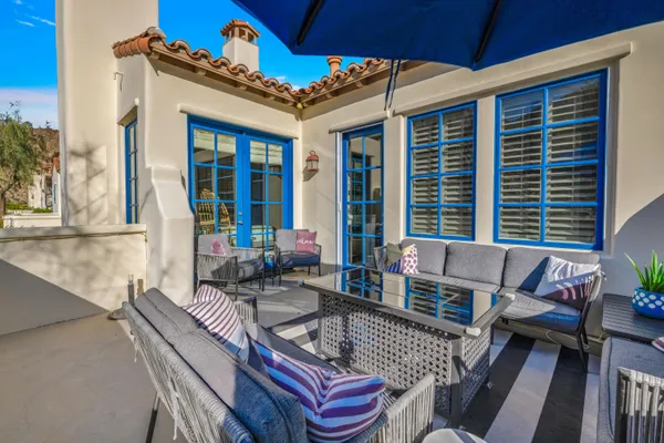a view of a patio with couches table and chairs and potted plants