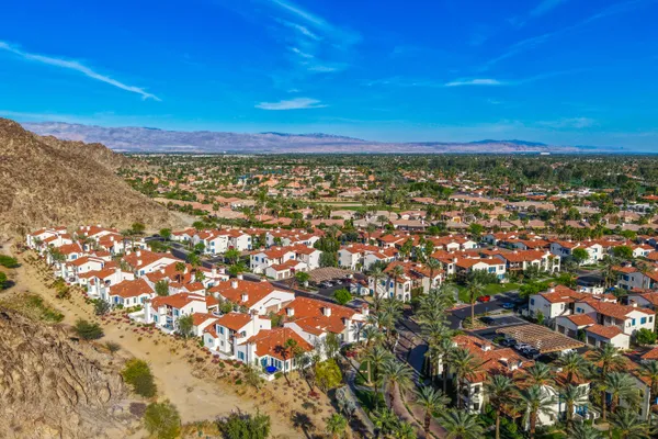 an aerial view of residential houses with outdoor space and parking