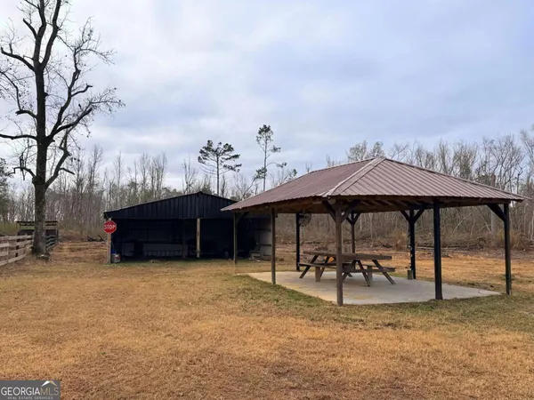 a view of a house with a yard and chair under an umbrella