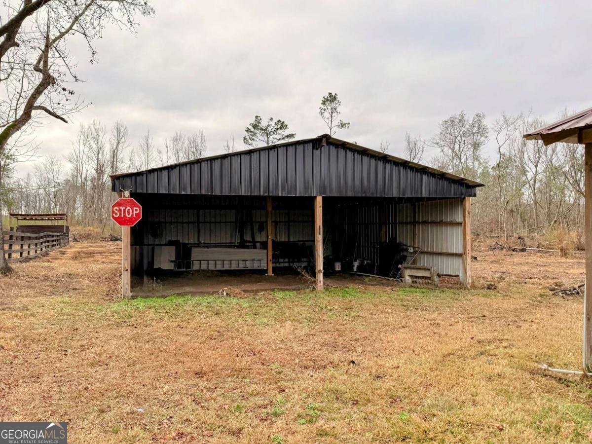147 McLoon Road Hazlehurst, GA 31539 - Photo 21 of 38 a view of a house with a yard and chair under an umbrella