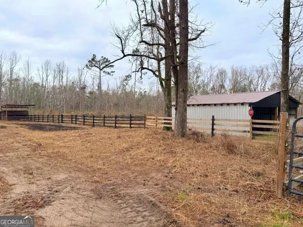 a view of a yard with wooden fence