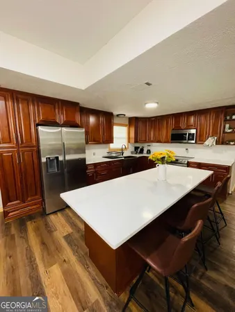 a living room filled with furniture and kitchen view