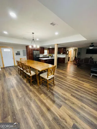 a living room with a table chairs and a wooden floor