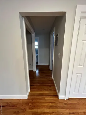 a view of a hallway with wooden floor