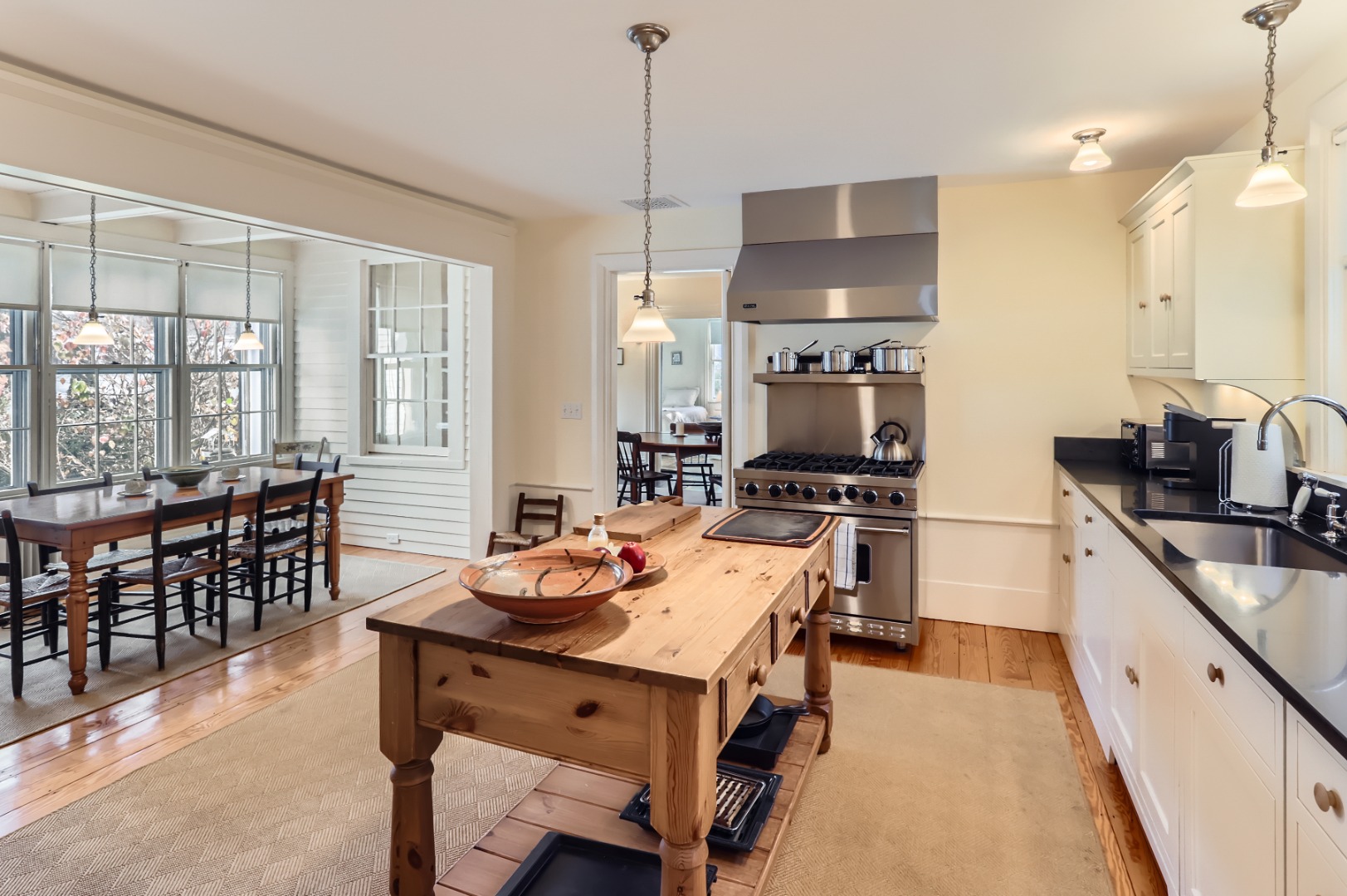 27 Spring Street Vineyard Haven, MA 02568 - Photo 14 of 59 a kitchen with a stove a sink dishwasher a dining table and chairs with wooden floor
