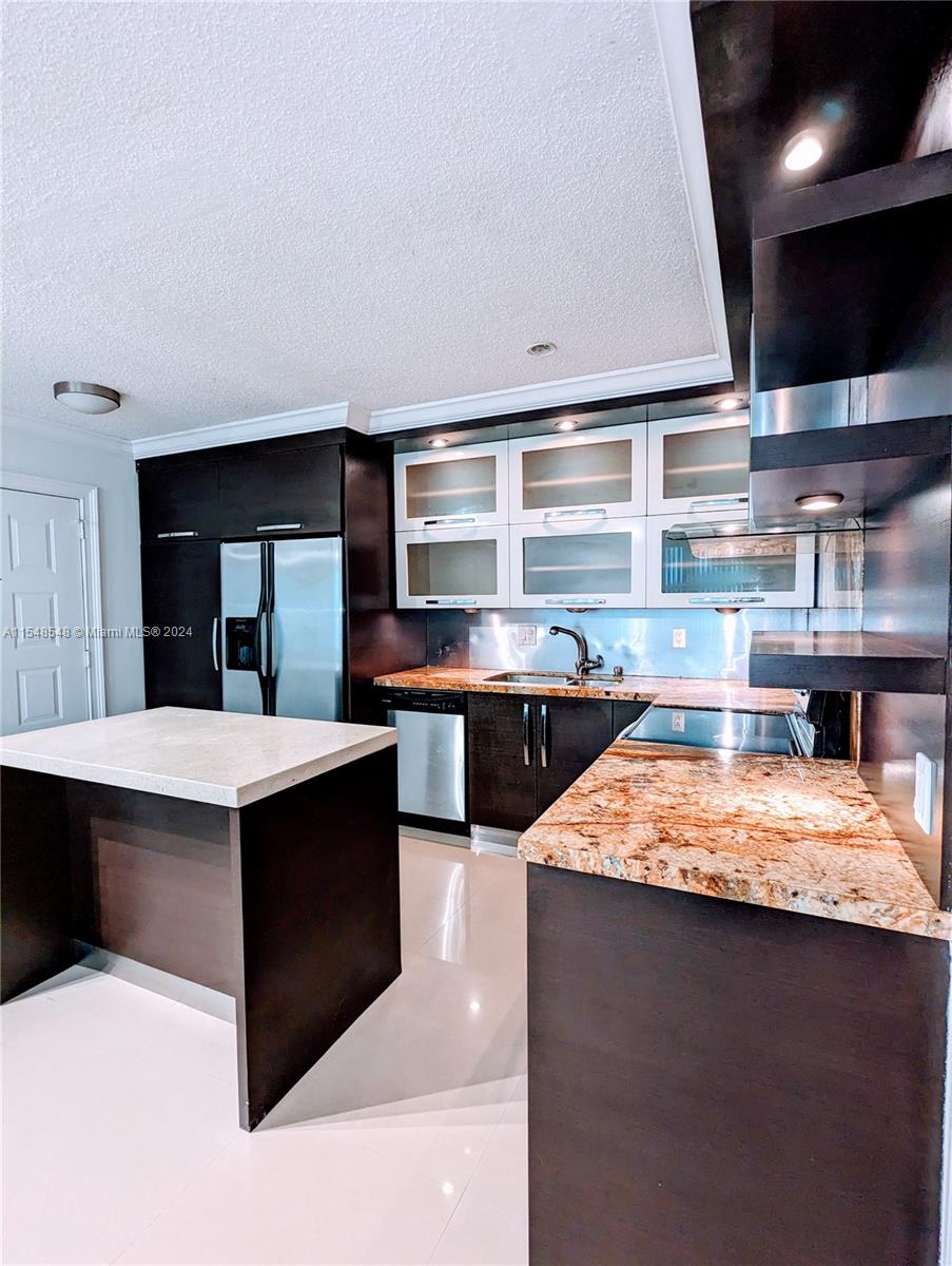 a kitchen with stainless steel appliances kitchen island granite countertop a stove and a sink
