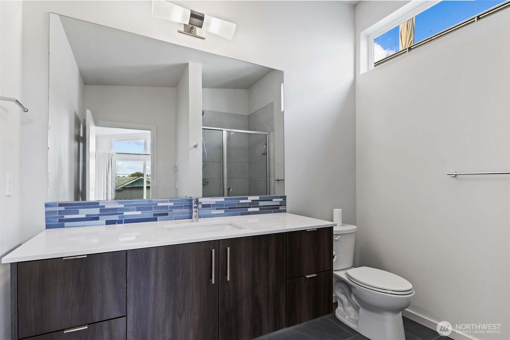6917 Carleton Avenue South, Unit B Seattle, WA 98108 - Photo 17 of 25 a bathroom with a granite countertop toilet a sink and a mirror