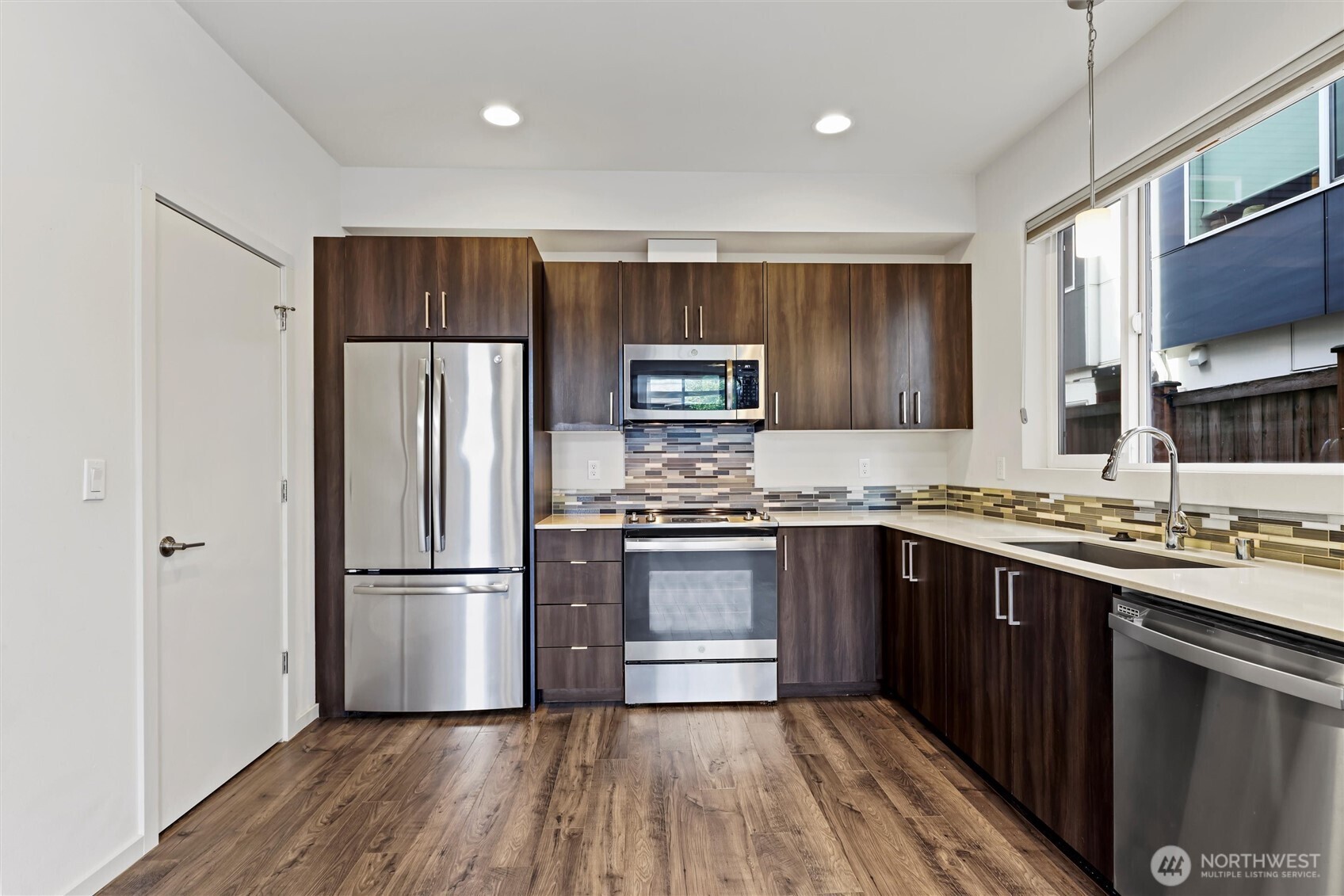 6917 Carleton Avenue South, Unit B Seattle, WA 98108 - Photo 7 of 25 a kitchen with a refrigerator sink and wooden floor