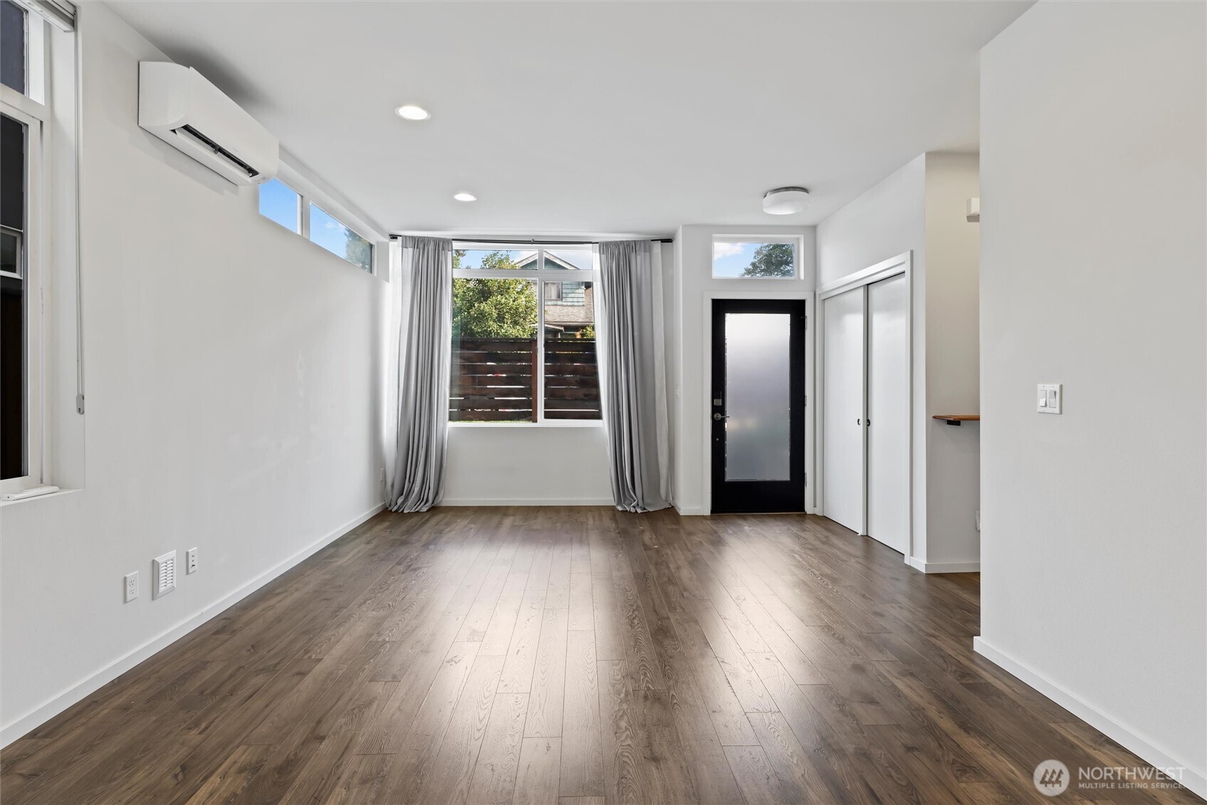 6917 Carleton Avenue South, Unit B Seattle, WA 98108 - Photo 9 of 25 an empty room with wooden floor and windows