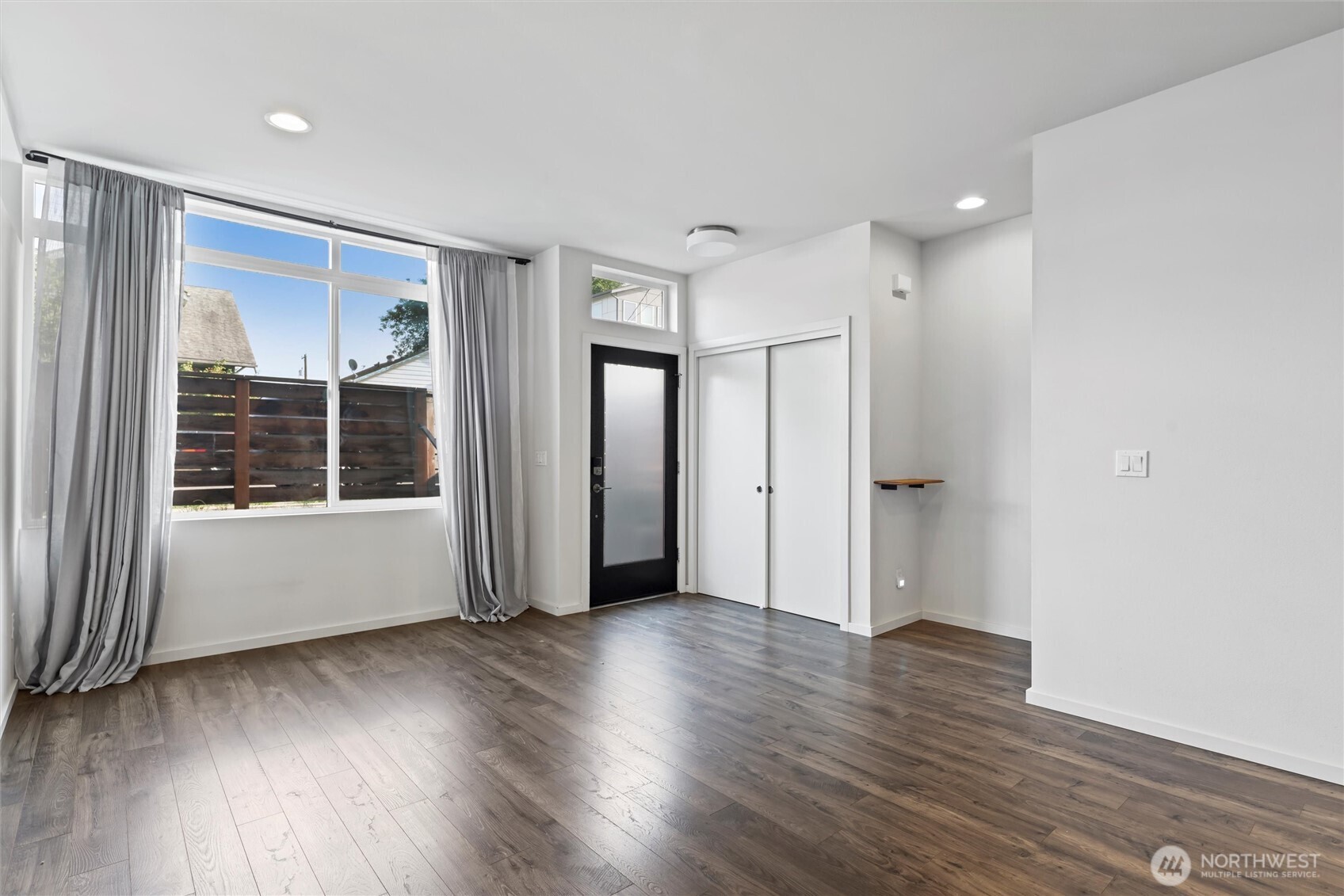 6917 Carleton Avenue South, Unit B Seattle, WA 98108 - Photo 10 of 25 a view of a big room with wooden floor and windows